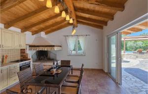 una cucina e una sala da pranzo con tavolo e sedie di Villa Funcici a Lovrinići