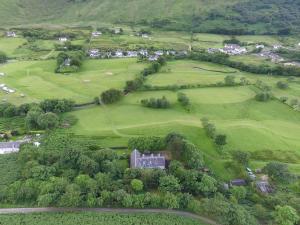 an aerial view of a house in a green field at Butt Lodge in Lochranza +15 photos