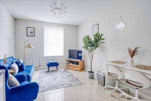 a living room with a blue couch and a table at Blue Horizon 1-Bedroom Apartment Near Hospital in Cardiff