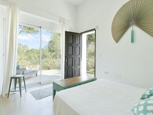 マドリードにあるVilla in Sant Josep near Beautiful Beachesのベッドと大きな窓のある白い寝室 +32枚の写真