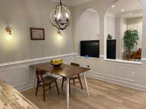 ein Esszimmer mit Tisch und Fernseher in der Unterkunft Cozy Townhome with luxury feelings in Frederick