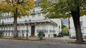 a white building with a balcony on a street at Appartement cozy 2 chambres in Luchon