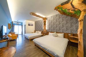 a bedroom with two beds and a living room at 緣木屋庭園民宿 in Dongshan