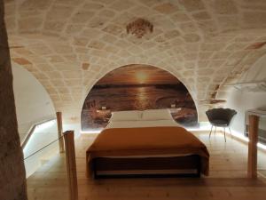 a bedroom with a bed in a stone wall at Dimora Fajano in Fasano