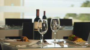 stół z dwoma kieliszkami do wina i talerzem jedzenia w obiekcie Hippocampus Resort & Spa w mieście Concón