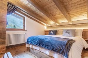a bed in a room with a wooden ceiling at HelloCHALET - Casa Val - Your Walking Distance holiday in Valtournenche