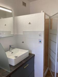 a white bathroom with a sink and a shower at Les Chênes-lièges d'Ambeille in Collioure