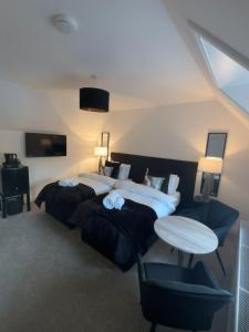 a hotel room with two beds and a table at Eden Rooms Peterhead in Peterhead