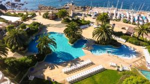an overhead view of a pool with palm trees and the ocean at Hippocampus Resort & Spa in Concón