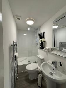 a white bathroom with a toilet and a sink at Eden Rooms Peterhead in Peterhead +24 photos