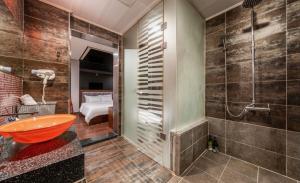 a bathroom with a shower and a orange sink at The Oreun Echae Hotel in Jeju