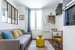 a living room with a couch and a table at Cosy 2 PIECES CHAMPS-ÉLYSÉES-DEFENSE in Puteaux