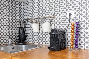a kitchen counter with a sink and a wall at Cosy 2 PIECES CHAMPS-ÉLYSÉES-DEFENSE in Puteaux +27 photos