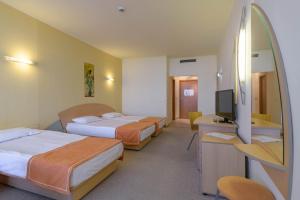 a hotel room with three beds and a television at Atlas Hotel - Ultra All Inclusive in Golden Sands