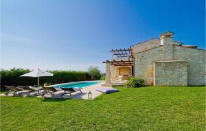 a house with a pool and some chairs and an umbrella at Villa Livia in Sovinjak