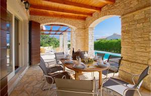 a patio with a table and chairs and a pool at Villa Livia in Sovinjak