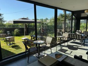 a room with glass windows and tables and chairs at One Suit in Kartepe