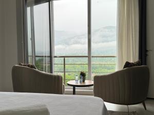 a bedroom with a bed and two chairs and a table at One Suit in Kartepe +6 photos