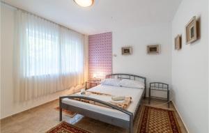 a bedroom with a bed and a large window at Beautiful Apartment In Premantura in Premantura