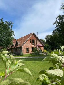 an old brick house in a yard with green grass at Hinners-Hoff Apartments in Bendingbostel
