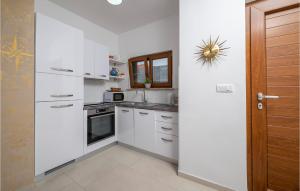 a kitchen with white cabinets and a stove top oven at 2 Bedroom Nice Apartment In Medulin in Medulin