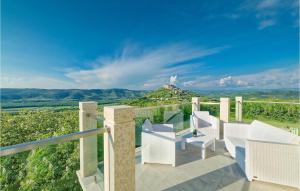 an outdoor balcony with white chairs and a view at Villa Demetra in Motovun