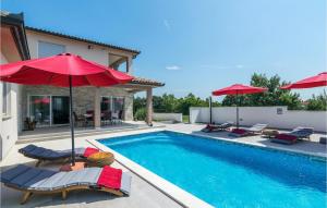 a swimming pool with chairs and umbrellas next to a house at Villa Lena in Sarići