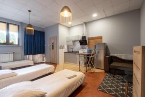a room with three beds and a kitchen at Apartamenty Komfort in Częstochowa