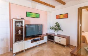 a living room with a television on a cabinet at Two-Bedroom Apartment In Komarna in Klek
