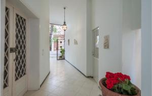 a hallway with a vase of red flowers in a pot at Cozy Apartment In Cattolica With Wifi in Cattolica