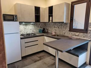 a kitchen with a white refrigerator and a table at Le Nonne HOUSE - Assemini - free parking in Assemini
