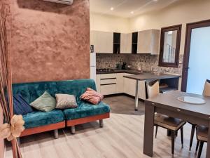 a living room with a couch and a kitchen at Le Nonne HOUSE - Assemini - free parking in Assemini