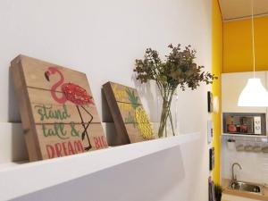 a shelf with two books and a vase of flowers at Heritage Loft on Beach Street near UNESCO Zone & Street Art 1 in George Town +22 photos