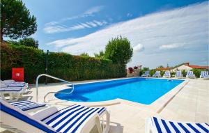 una piscina con sedie a sdraio accanto a una siepe di Villa Old School House a Bašići