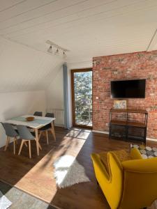 a living room with a brick wall and a table and chairs at Apartmany Calma in Liptovský Mikuláš