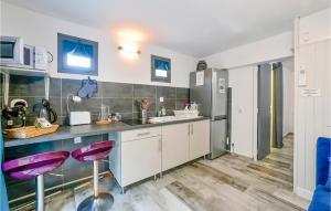a kitchen with purple stools in a room at Beautiful Apartment In Vallon Pont Darc in Vallon-Pont-dʼArc