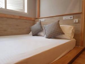 a bed with two pillows on it in a room at Heritage Loft on Beach Street near UNESCO Zone & Street Art 2 in George Town