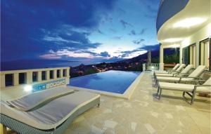 a villa with a swimming pool and lounge chairs at Amazing Home In Makarska in Makarska