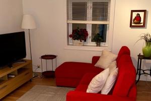 a living room with a red couch and a television at Panoramic Fjord View near Bergen in Bergen