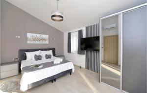 a bedroom with a bed and a flat screen tv at Awesome Home In Starigrad Paklenica in Starigrad-Paklenica