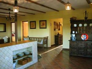 a living room with a kitchen with a fireplace at Casa Rural Balcón del Camino Viejo in Valencia de Alcántara