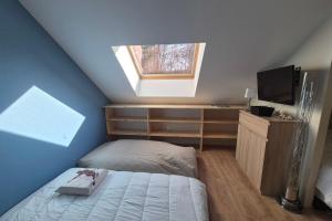 a attic bedroom with a bed and a window at Appartement 4 personnes avec accès piscine in La Féclaz