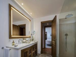 een badkamer met een wastafel en een spiegel en een douche bij Elegant villa with communal space in Banyalbufar +33 foto's
