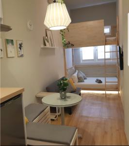 Heritage Loft on Beach Street near UNESCO Zone & Street Art 3 في جورج تاون: غرفة معيشة صغيرة مع طاولة وسرير بطابقين