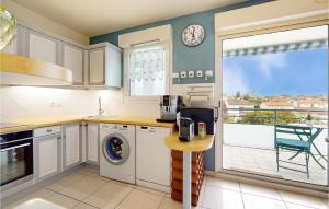 eine Küche mit einem Geschirrspüler und einer Uhr an der Wand in der Unterkunft Lovely Apartment In Royan With Wifi in Royan + 19 Fotos