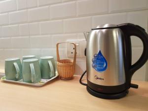 Heritage Loft on Beach Street near UNESCO Zone & Street Art 3 في جورج تاون: غلاية الشاي موجودة على كاونتر بجوار أكواب