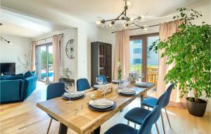 a dining room with a wooden table and blue chairs at Villa Suncica in Sukošan