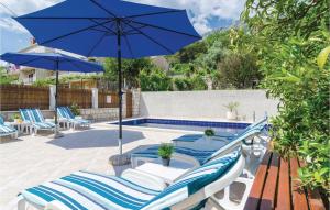a patio with chairs and an umbrella next to a pool at Holiday Home Obuljeno Donje Iii in Mokošica +52 photos