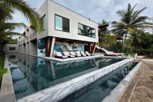 a house with a swimming pool in front of a house at Lujoso Studio Frente al Mar in Troncones