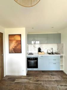 a white kitchen with a sink and a dishwasher at T2 niché entre mer et montagne in Ollioules